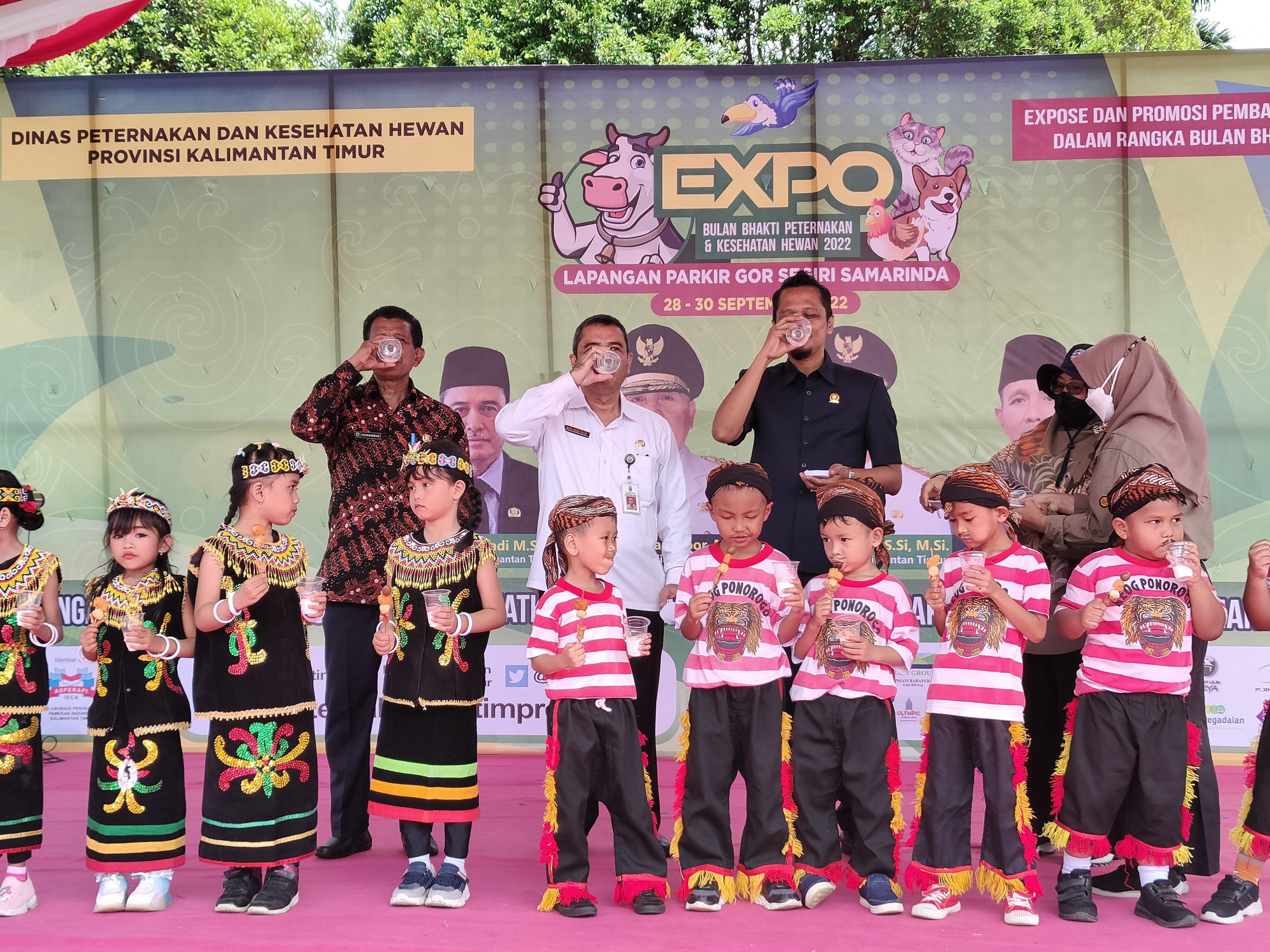DUKUNG: Ketua Komisi II DPRD Kaltim Nidya Listiyono (kanan), Penjabat (Pj) Sekda Riza Indra Riadi (tengah), Kepala Disnakkeswan Kalimantan Timur Munawwar (kiri) melakukan sesi foto bersama anak-anak sambal meminum segelas air susu.
