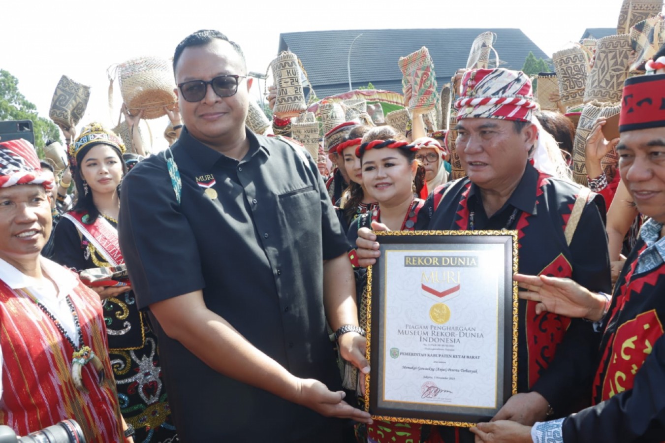 SPESIAL: Awan Rahargo menyerahkan plakat rekor Muri kepada Bupati Kutai Barat FX Yapan disaksikan masyarakat berjumlah belasan ribu orang.