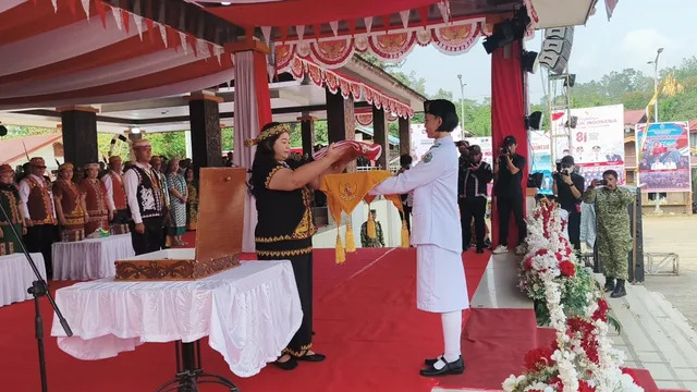 Bupati Mahakam Ulu Angela Idang Belawan menyerahkan baki Merah Putih kepada anggota Paskibraka dalam rangkaian peringatan HUT ke-81 Kemerdekaan Republik Indonesia di Kabupaten Mahakam Ulu.